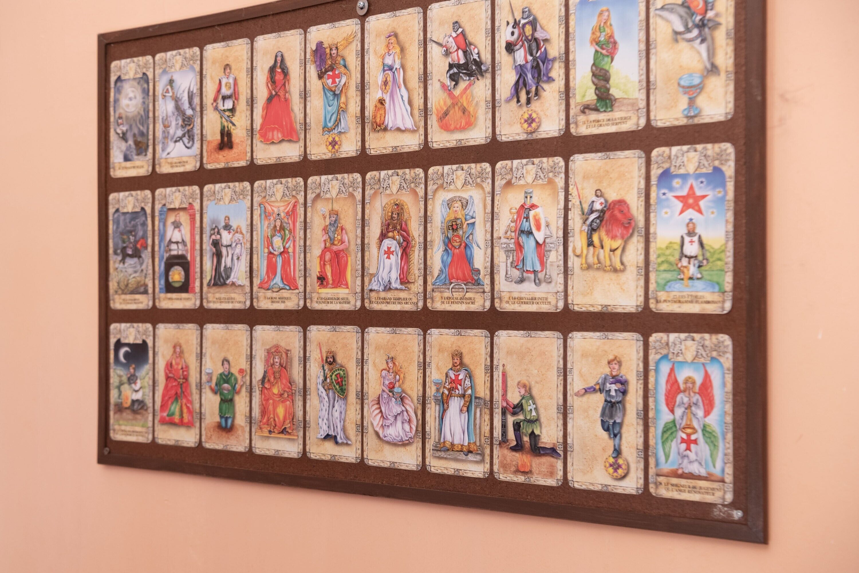 Eine Wand mit einer gerahmten Sammlung von Tarotkarten.