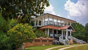 A two-story building with a balcony, a staircase, and a brick wall. - Johns Village  (Mulanthuruthy)