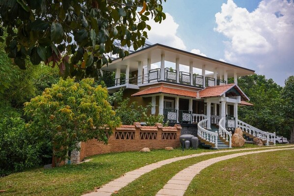 A two-story building with a balcony, a staircase, and a brick wall. - Johns Village  (Mulanthuruthy)