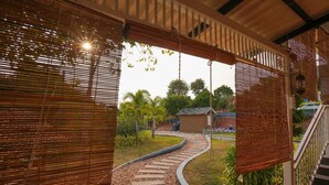 A covered outdoor area with a stone pathway leading to a small building. - Johns Village  (Mulanthuruthy)