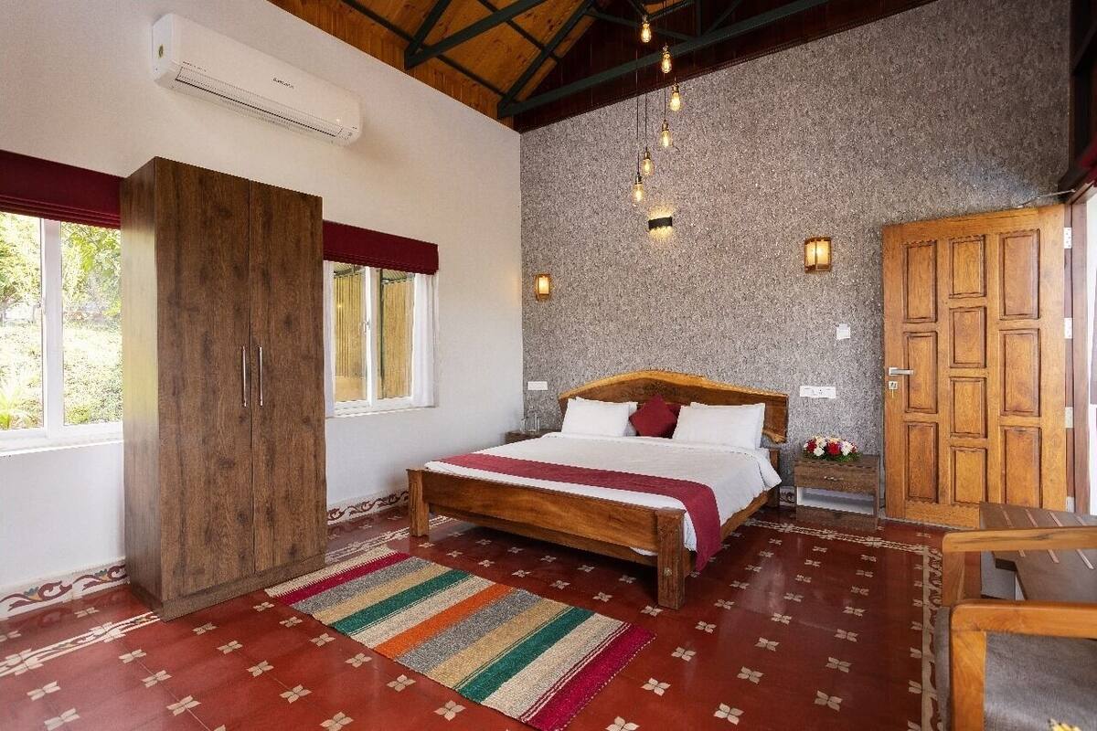 Ein Schlafzimmer mit einem hölzernen Bett, einem Schrank, einem Nachttisch und einer Steinwand.