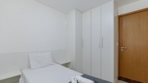 A small, single-bed room with a wooden door and white walls. - 2 Bedroom Apartment 700 m From the Beach Mbr0108 (Maceió)