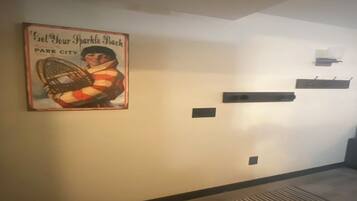 Un pasillo con un cartel antiguo, una rejilla de ventilación y un estante negro.