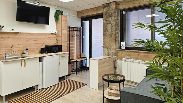 A modern kitchen with a built-in microwave, a wooden countertop, and a hanging plant. - Real 43 Casa Neda (neda)