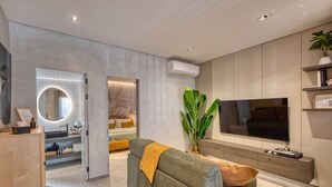 A modern living room with a sofa, a TV, and a plant. - Designer Penthouse by the Promenade | BBQ Terrace (Gzira)
