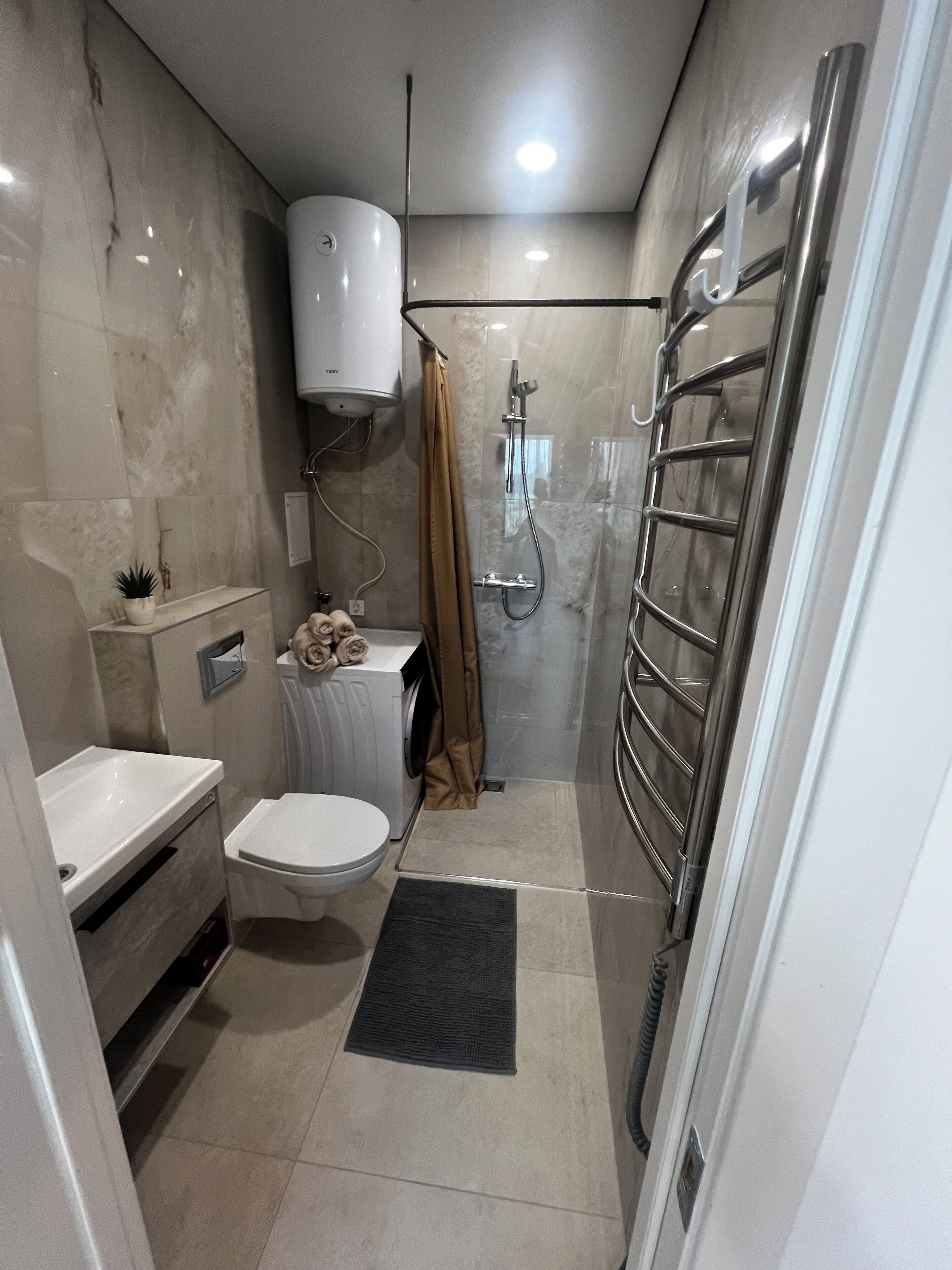 A modern bathroom with a toilet, sink, and shower.