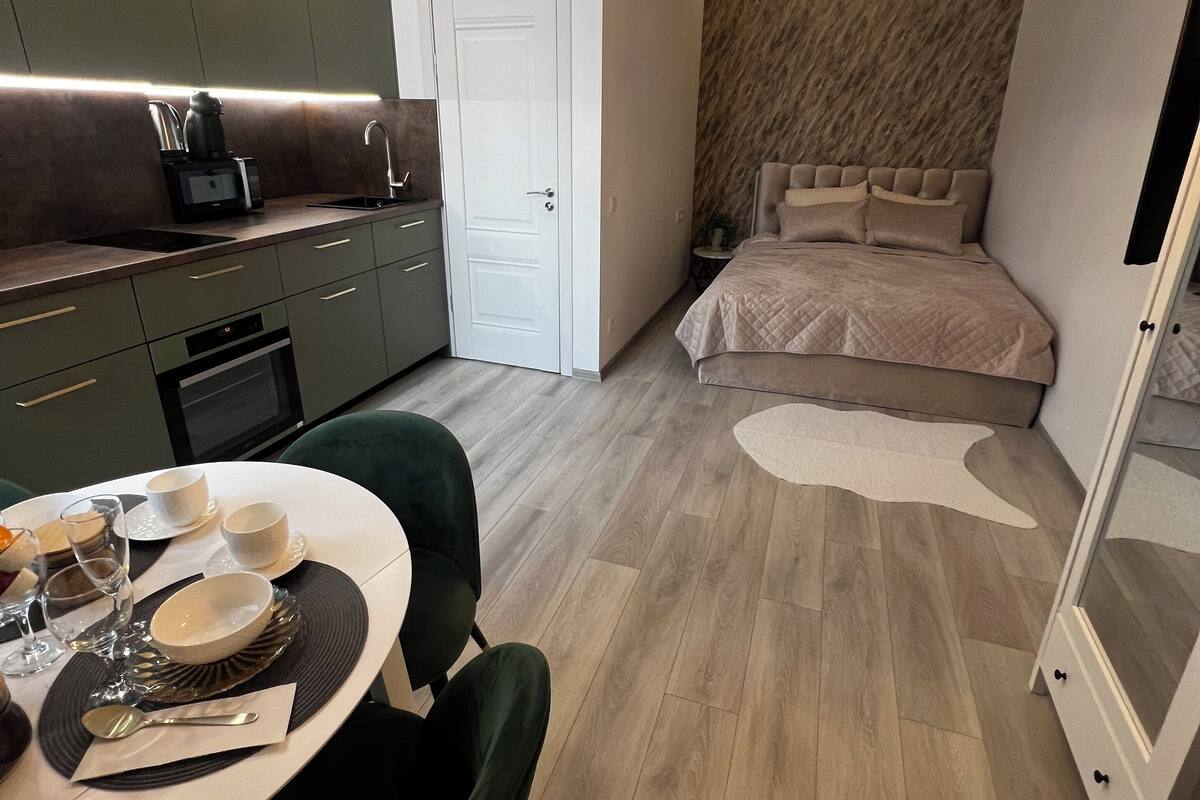 A modern bedroom with a large bed, a nightstand, and a chandelier.