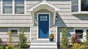 A house with a blue front door, number 36, and a small porch with steps. - Surfside Sanctuary at Gooch's Beach (Kennebunk)