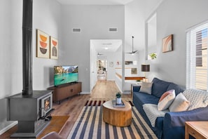 Un salon moderne avec une cheminée, un téléviseur, un canapé et une table basse.