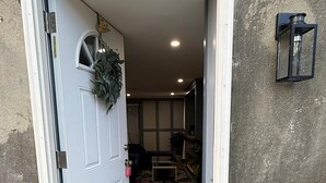 Ein Durchgang zu einem Raum mit gefliestem Boden und einem gemusterten Teppich.