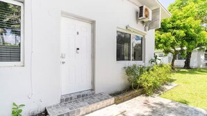 A white house with a front door, a small porch, and a window. - Stylish Stay Minutes from Wynwood & Midtown (Miami)