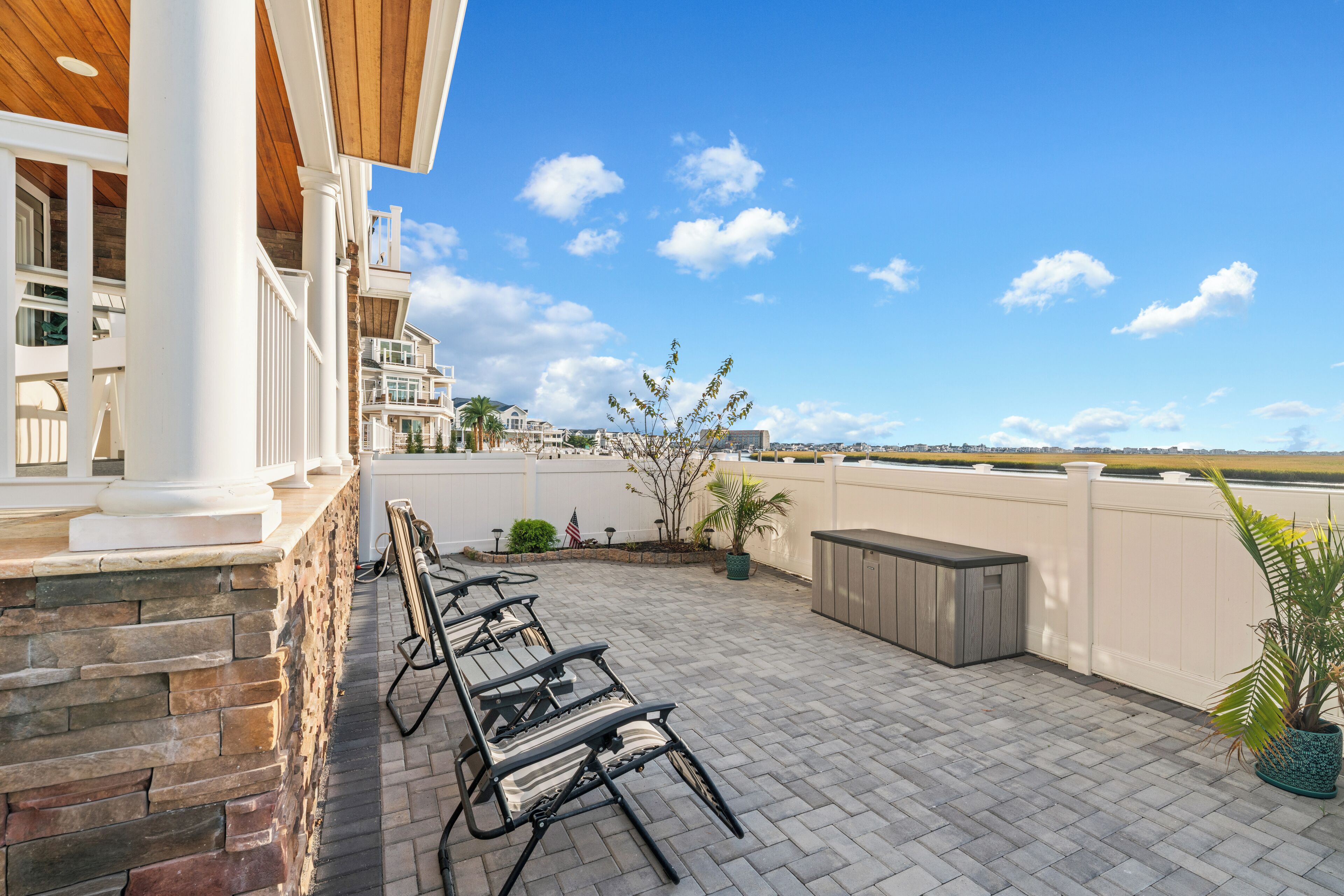 A patio with outdoor furniture, a stone wall, and a view of the landscape.