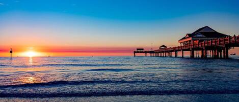 A pier extending into the ocean with a building at the end.