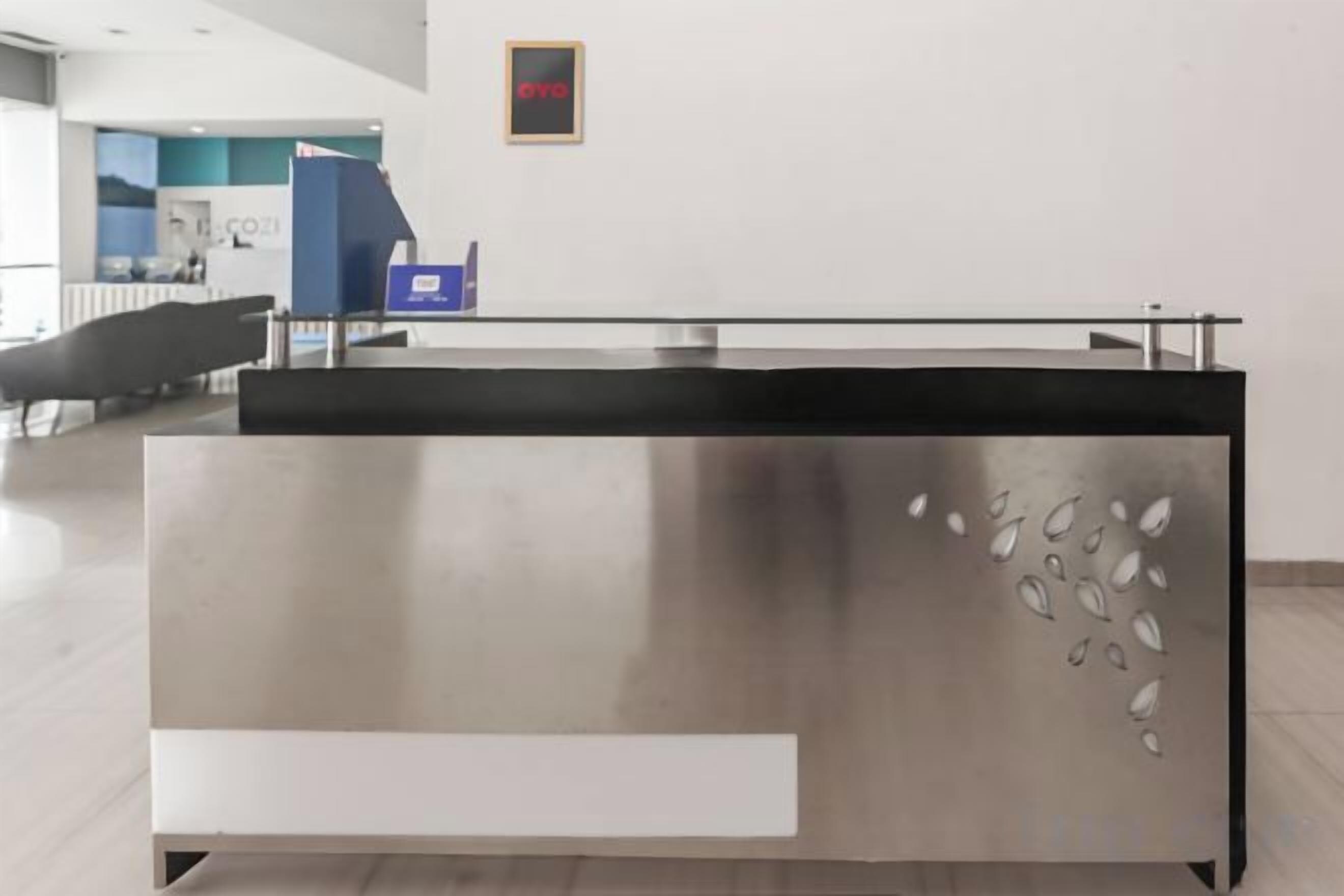 A reception desk with a modern design, a blue counter, and a framed picture on the wall.