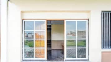 A building entrance with a glass door and a window to the right.