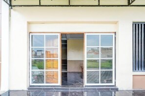 La entrada de un edificio con puerta de cristal y una ventana a la derecha.