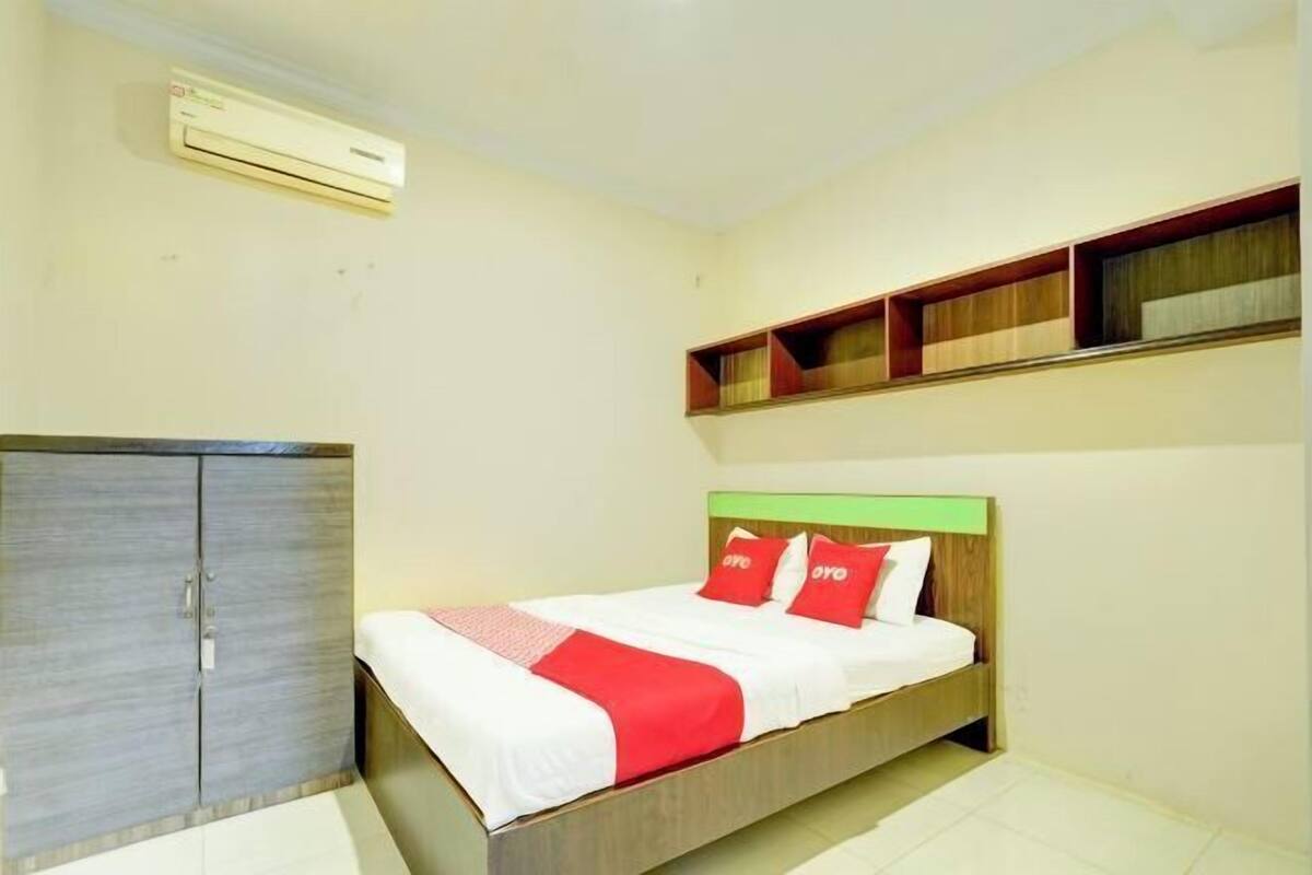 Une chambre à coucher comprenant un lit, une armoire et des étagères intégrées.