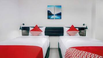 A hotel room with two beds, a nightstand, a lamp, and a painting on the wall.