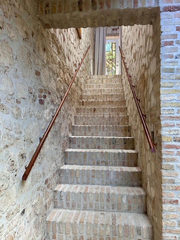 A stone staircase with wooden handrails leading to a door. - Treehouse - The Canopy (Christiansted)