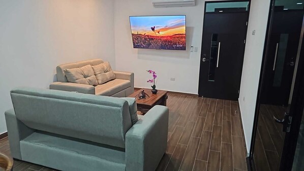 Habitación superior con 1 cama doble o 2 individuales, vistas a la montaña | Zona de estar | Televisión de pantalla plana de 55 pulgadas con canales por cable