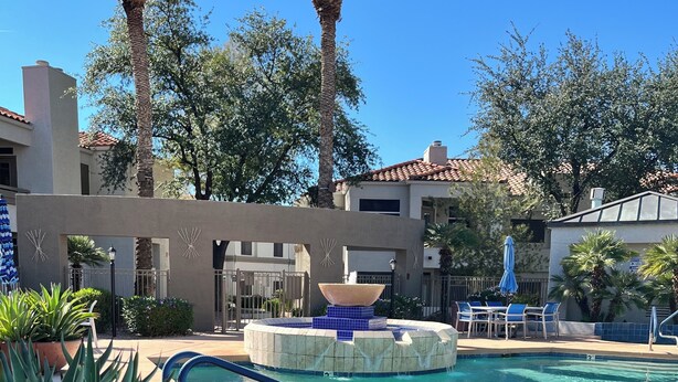 A swimming pool with a clear blue water surface, surrounded by lounge chairs and a palm tree. - Dog-Friendly Cozy Condo in North Scottsdale! (Scottsdale)