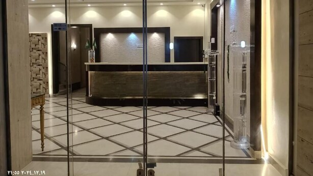 A reception area with a check-in counter, a tiled floor, and a modern interior design. - Diyra Hira (Jeddah)