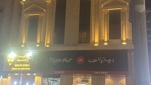 A building with a large arched entrance and a sign for 'Dazzahut'. - Diyra Hira (Jeddah)