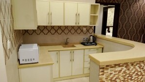 A compact kitchen with a microwave, sink, and cabinets. - Diyra Hira (Jeddah)