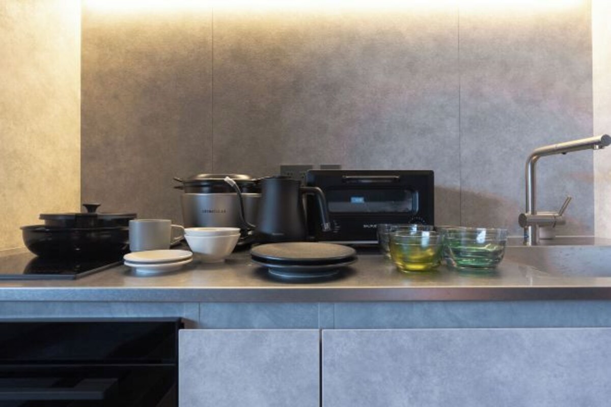 Una cocina equipada con microondas, cafetera y diferentes utensilios.