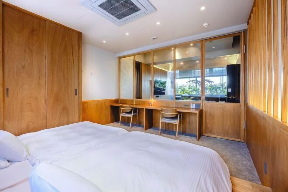 A bedroom with a bed, a desk, and a wardrobe.