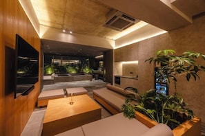 Ein modernes Interieur mit einer Couch, einem Couchtisch und einem an der Wand montierten Fernseher.