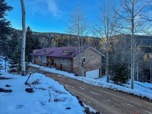 A house with a sloped roof, a front porch, and a garage. - Luxury Angel Fire 5BR 4B, Views!, Game Room (Angel Fire)