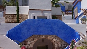 A courtyard with a stone archway, white walls, and blue accents. - "Rincon de Marinos", a spacious house in a quiet estate, 5 mins. from the beach (Almuñécar)