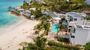 En ejendom ved kysten med swimmingpool, badestrand og en anløbsbro.
