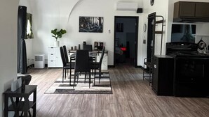 Een moderne keuken met een eethoek, met een gebogen plafond en houten vloer.
