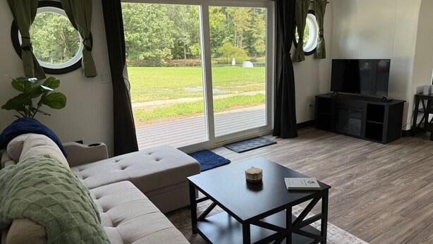 Ein modernes Wohnzimmer mit einer Couch, einem Couchtisch und einem Fernseher.