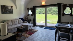 Ein geräumiges Wohnzimmer mit einer Couch, einem Couchtisch und einem Essbereich mit Stühlen und einem Tisch.