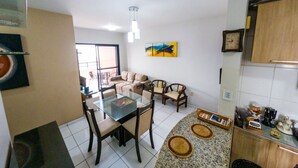 A modern living space with a dining area, kitchen, and a balcony.