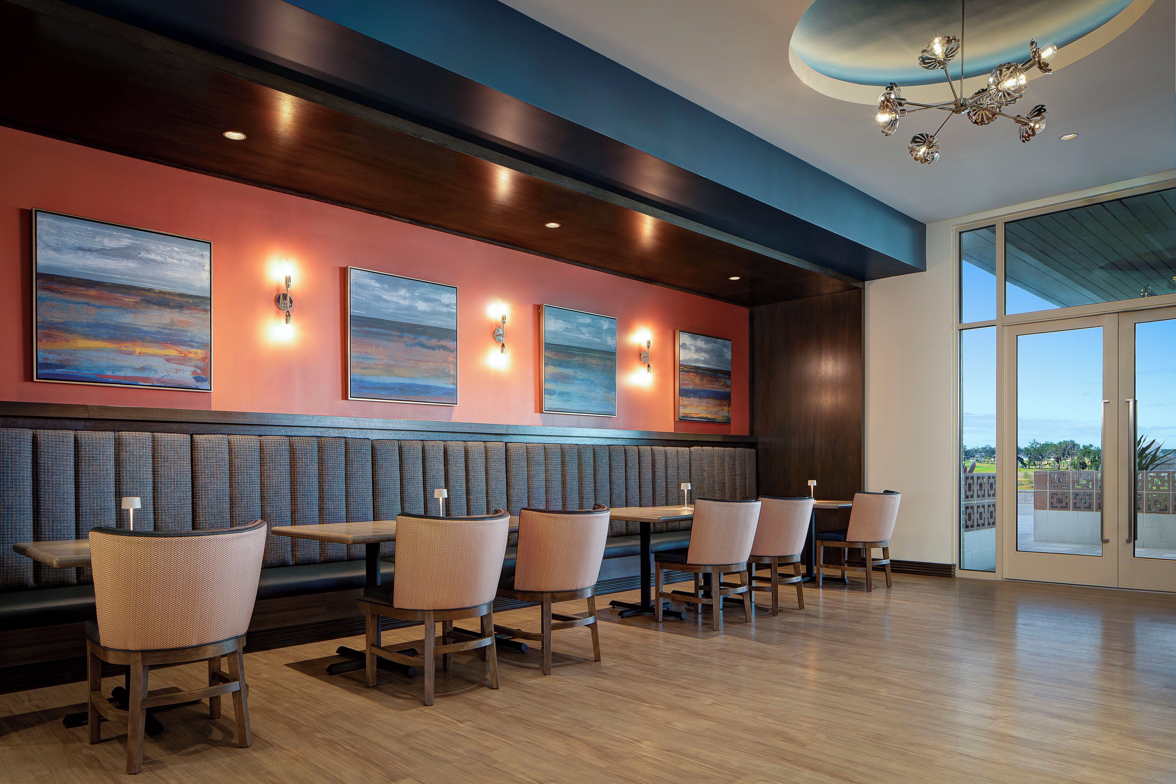 Un restaurant doté d’un long banc, de tables et de chaises.