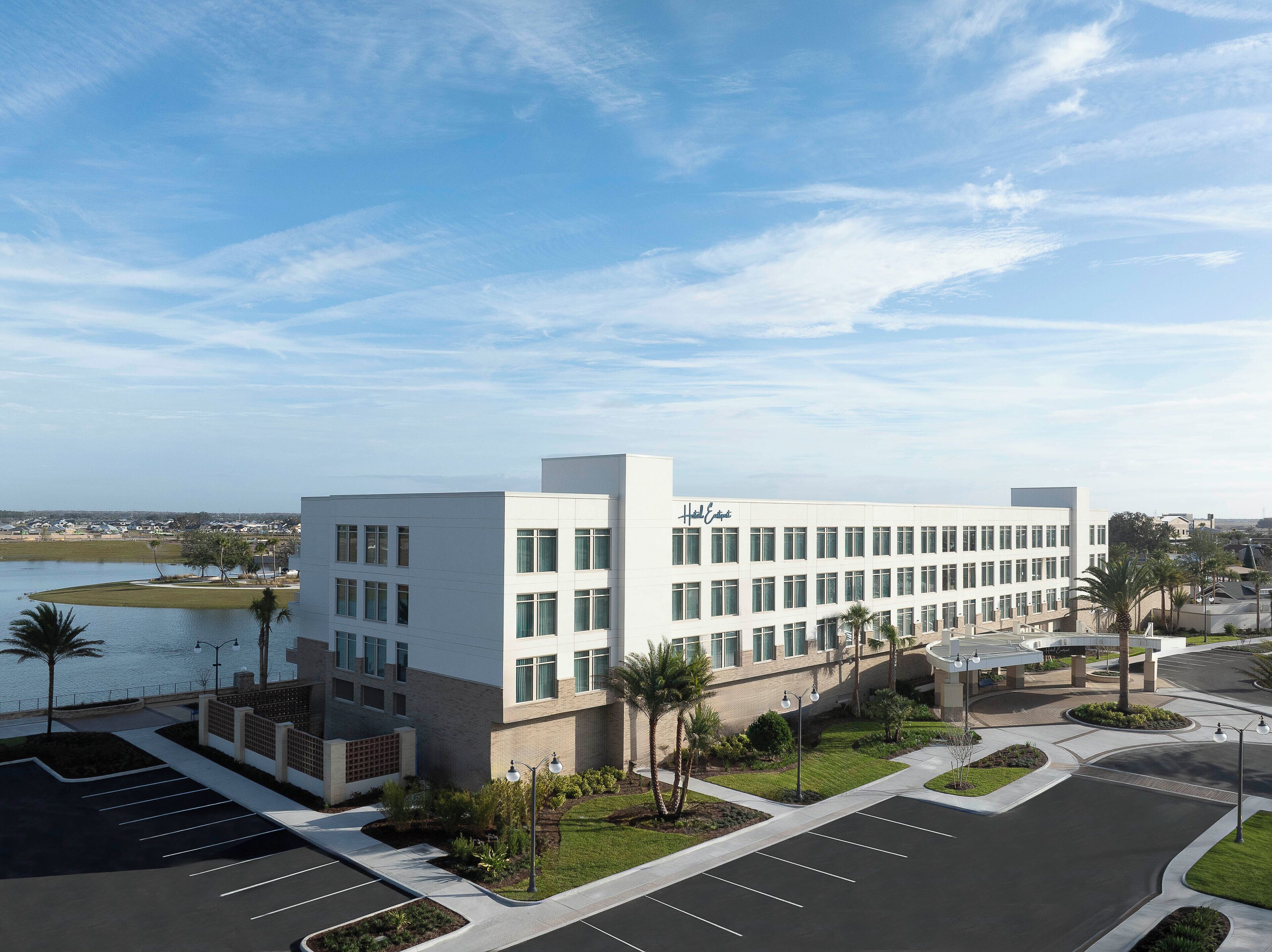 A modern hotel with a parking lot and a view of the water.