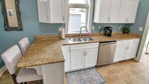 A kitchen with white cabinets, a granite countertop, a sink, and a dishwasher. - Blueberry Cottage - Downtown Park City (Park City)