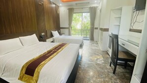 Habitación de hotel con dos camas, un escritorio, una silla y un balcón con vistas.