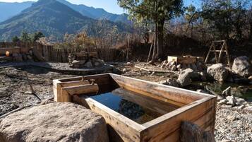 A wooden bathhouse with a wooden tub and a wooden bench.