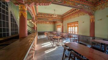 A traditional room with wooden furniture, a staircase, and ornate ceiling decorations.