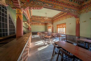 A traditional room with wooden furniture, a staircase, and ornate ceiling decorations.
