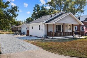 A single-story house with a front porch, a garage, and a small patio area with outdoor furniture.