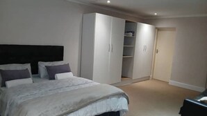 Un dormitorio con cama, armario y puerta.