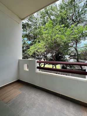 Quarto casal superior, sacada, vista parcial para o oceano | Escrivaninha, Wi-Fi de cortesia