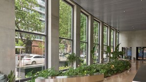 A spacious lobby with large windows, a central planter with greenery, and a modern design. - Alma Rentals Huergo 475 (Buenos Aires)