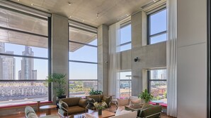 A spacious living area with large windows, a sofa set, a coffee table, and a potted plant. - Alma Rentals Huergo 475 (Buenos Aires)